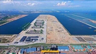 Modern Tuas Port in Singapore bustling with container ships and cranes, representing Asian maritime trade.