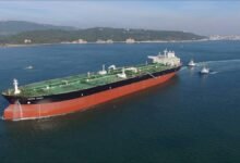 A large Teekay oil tanker sails across calm waters.