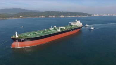 A large Teekay oil tanker sails across calm waters.