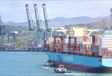 A large container ship navigates the Panama Canal, illustrating global shipping challenges.