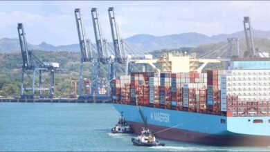 A large container ship navigates the Panama Canal, illustrating global shipping challenges.