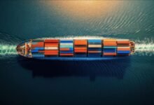 A large container ship navigating ocean waters, representing global maritime decarbonization efforts.