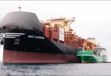Shell LNG bunkering vessel fueling a cargo ship at a port.