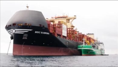 Shell LNG bunkering vessel fueling a cargo ship at a port.