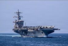 The USS Abraham Lincoln aircraft carrier at sea with planes on its flight deck.