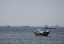 A large cargo ship navigates the vital Strait of Hormuz shipping lane.