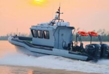 A patrol boat on the water powered by multiple Cox Marine diesel outboards.