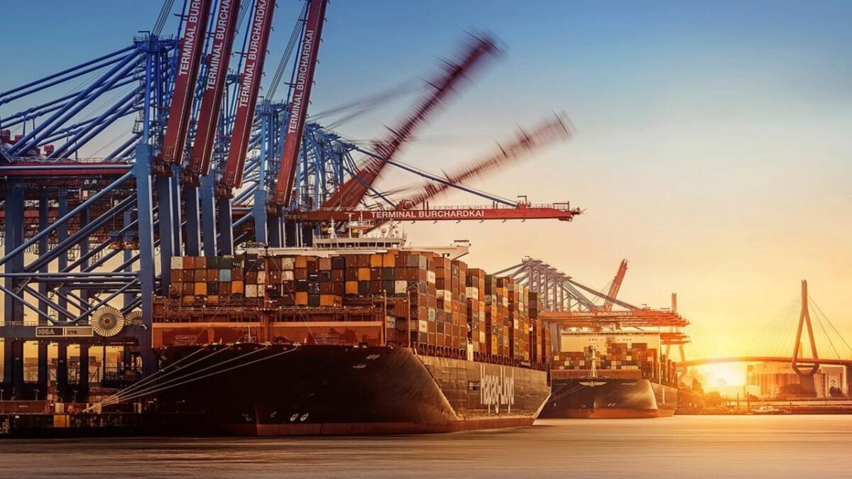 Large container ship laden with cargo sails, representing global shipping.