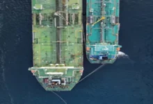 A large cargo vessel sails across the open ocean, representing marine fuel consumption.