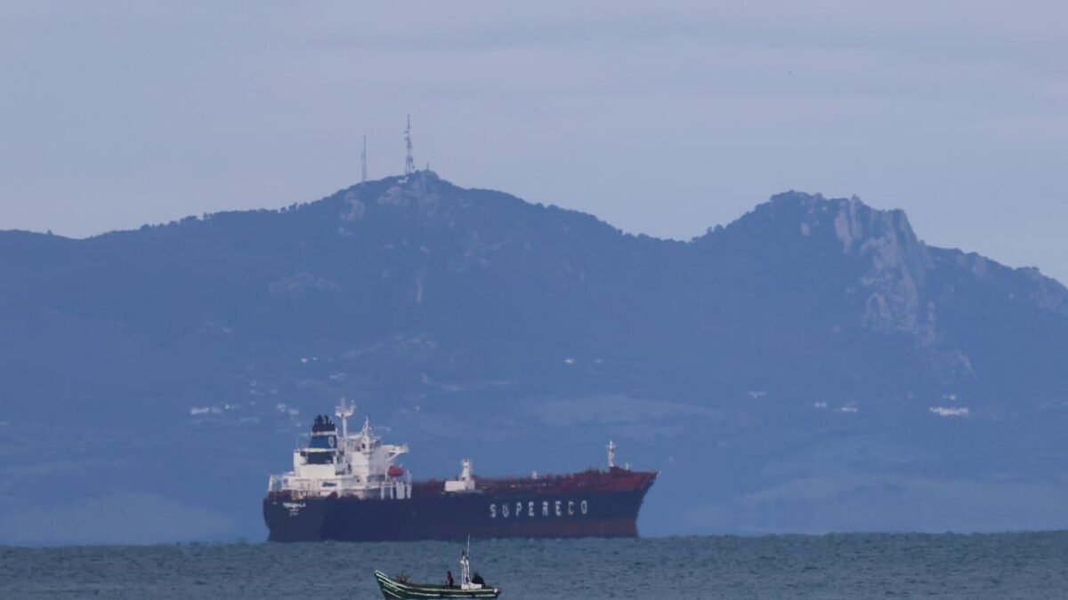 A large oil tanker ship sails on blue ocean waters under a clear sky.