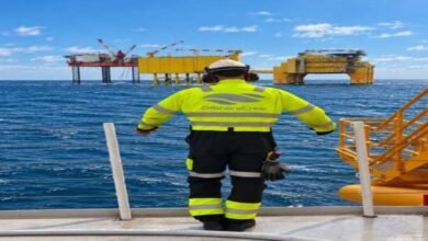 An offshore supply vessel with cranes and personnel on deck, supporting specialized operations.