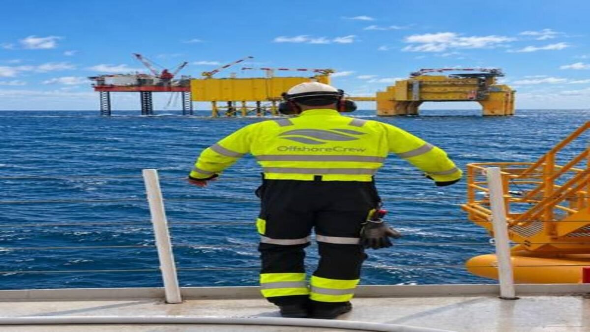 An offshore supply vessel with cranes and personnel on deck, supporting specialized operations.