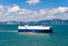 A modern LNG dual-fuel car carrier (PCTC) sails, symbolizing Global Car Carriers' growth.