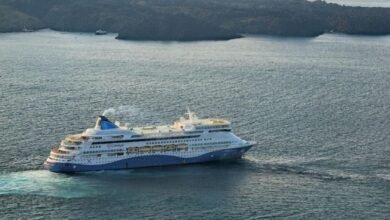 A white Celestyal cruise ship sails across the blue Mediterranean Sea.