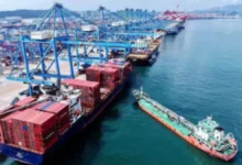A large container ship with colorful cargo containers at a port, symbolizing international trade.