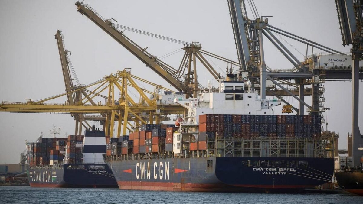 Container ships and cranes at a busy European port terminal.