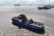 The blue-hulled Wind of Ocean Service Operation Vessel sails past offshore wind turbines.