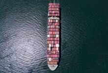 A large container ship navigates open waters, symbolizing global trade and maritime activity.