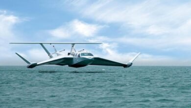 A large commercial ground effect vehicle flies low over a rough, open ocean.