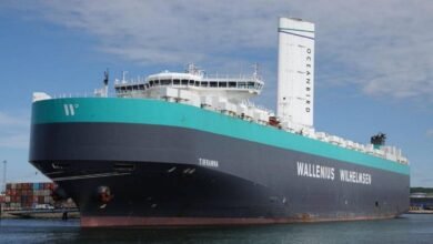 Wallenius Wilhelmsen car carrier with tall white Oceanbird wind sails at sea.