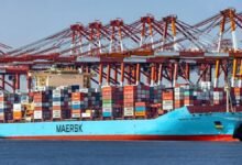 A large blue Maersk container ship travels on the ocean.