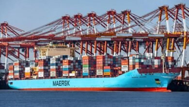 A large blue Maersk container ship travels on the ocean.