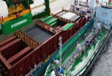 A large container vessel is bunkered by a tanker during cargo operations.