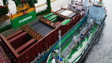A large container vessel is bunkered by a tanker during cargo operations.