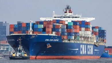 A large container ship in a port, representing CMA CGM's fleet and the Le Havre biomethane project.