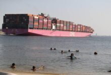 A large car carrier ship sails on the ocean, representing wind propulsion challenges for decarbonization.