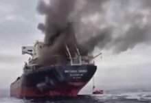 A ship on fire emits thick smoke after an attack in the critical Strait of Hormuz.
