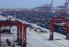Container ships docked at the advanced Yangshan Deep-water Port of Shanghai, with multiple cranes loading cargo.