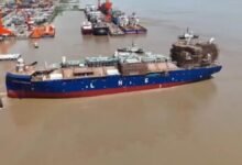 Avenir LNG's newbuild LNG bunkering vessel, white and red, is launched into the water.