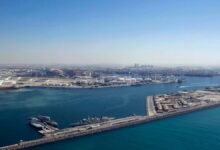 A modern DP World logistics center with shipping containers and trucks.