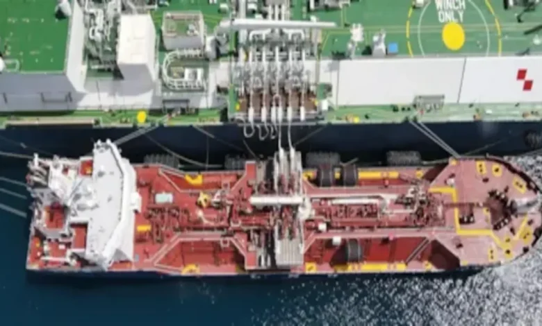 An LNG bunker vessel refuels a large cargo ship at sea.