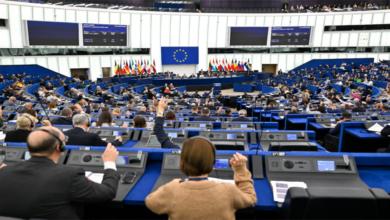 European Parliament members voting during a plenary session in the assembly chamber.