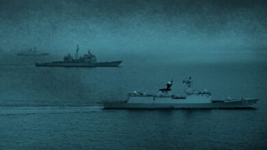 A large Chinese naval warship sails on open blue waters.