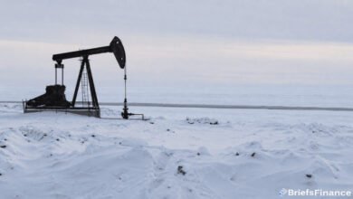 An industrial ship navigating through icy Arctic waters during offshore energy exploration.