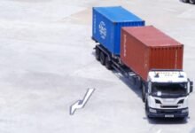 Automated gantry cranes move shipping containers at a bustling Singapore port.