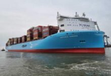 A large container ship loaded with cargo navigates a waterway for Asia-Europe Suez services.