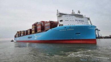 A large container ship loaded with cargo navigates a waterway for Asia-Europe Suez services.