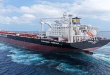CMB.TECH's 'Mineral Europa,' a large grey dry bulk carrier, sails on the ocean.