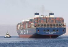 Multiple container ships dock at a large, bustling port with cranes, symbolizing global trade networks.